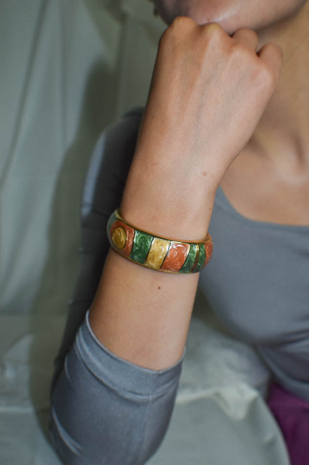 Close-up of a wrist wearing a colorful bracelet with a neutral background