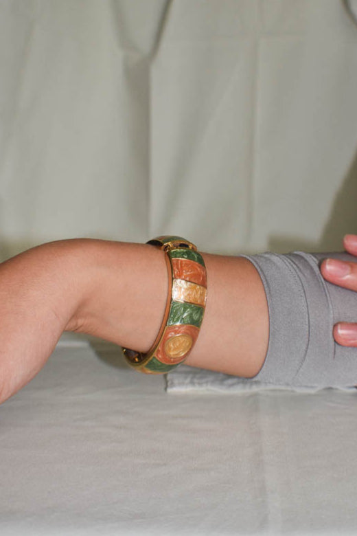 Person wearing a colorful bracelet on a neutral background