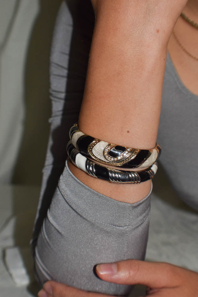 Close-up of a wrist wearing multiple bracelets with a neutral background