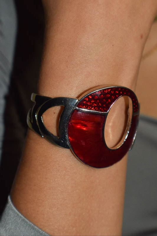 Close-up of a wrist wearing a red and silver bracelet.