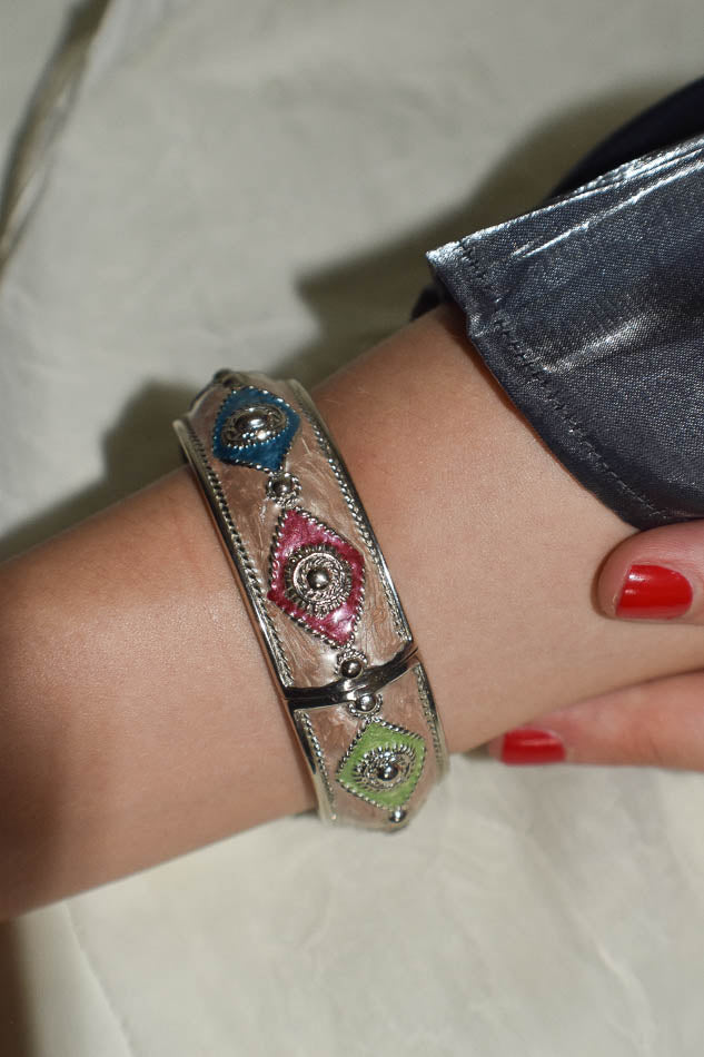 Close-up of a wrist wearing a decorative bracelet with colorful stones.