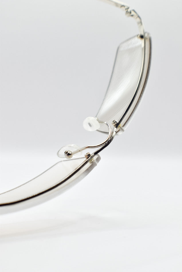 Close-up of silver famed glasses on a light gray background