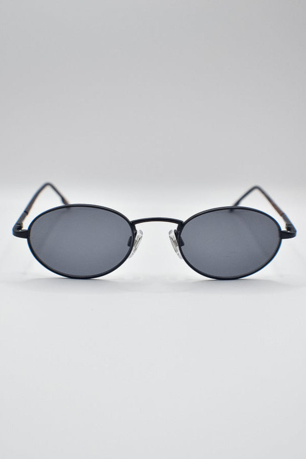 Round sunglasses with black lenses on a light gray background