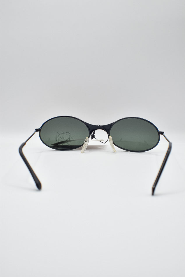 Sunglasses with dark lenses and thin frame on a light gray background