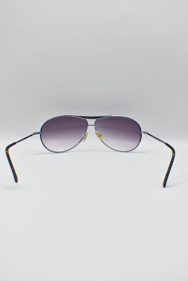 Aviator sunglasses with gradient lenses on a light gray background