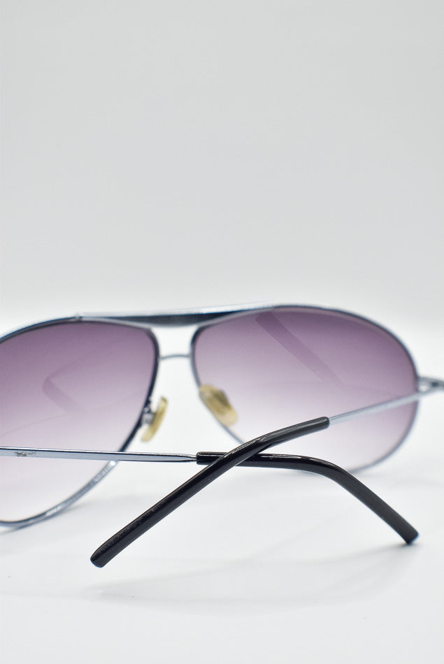 Aviator sunglasses with purple lenses on a white background