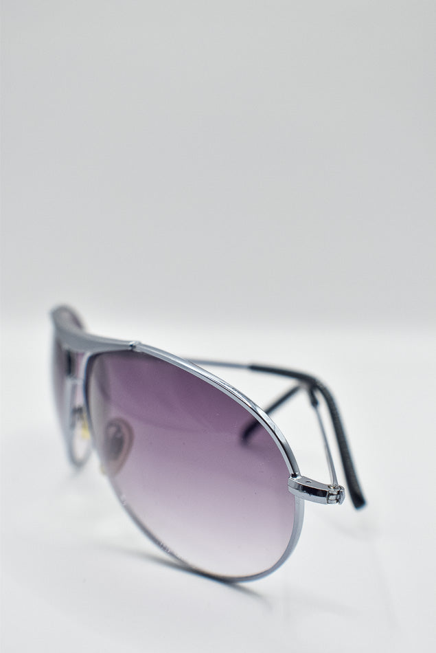 Sunglasses with a gradient purple lens on a white background