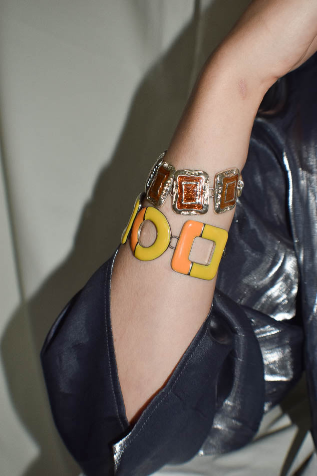 Close-up of a wrist wearing a colorful bracelet with geometric designs.