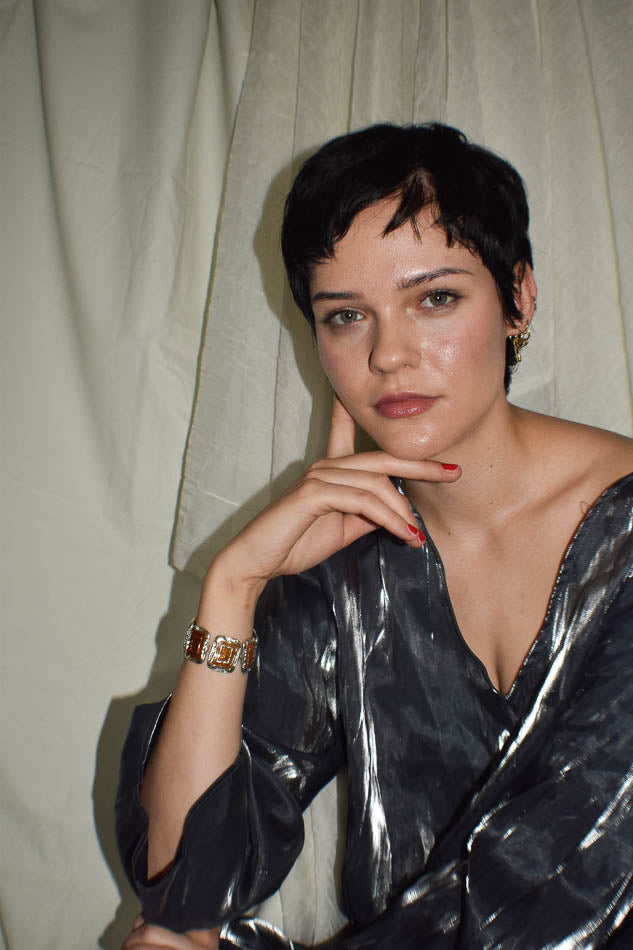 Woman wearing a metallic black dress against a plain background